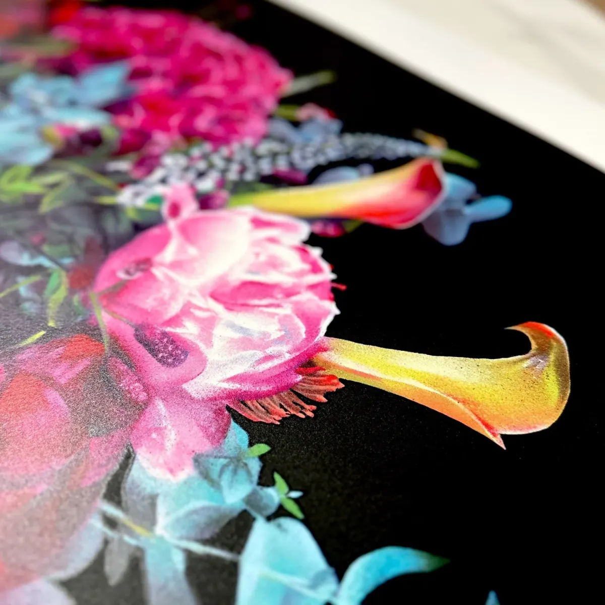 Pink flowers and yellow trumpet blooms against the black background of a fine art print