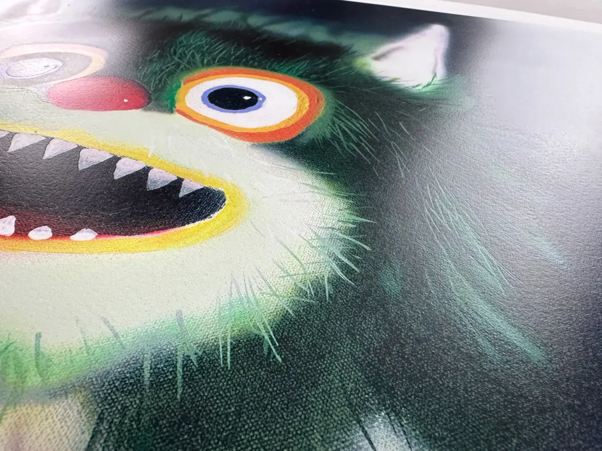 Detail of a green creature with a bright eye and open mouth in a screenprint